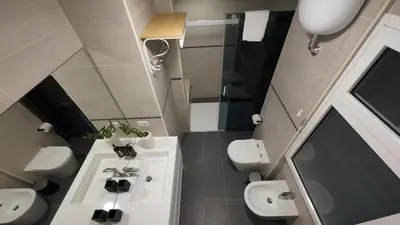 a small bathroom with a sink and two toilets at Sweet Home Fleming in Rome