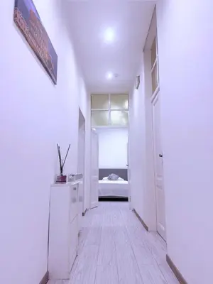 a hallway with white walls and a room with a bed at Gazi House in Rome