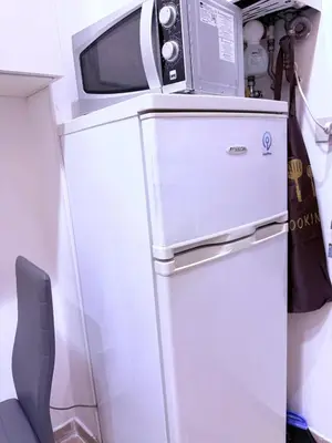 a microwave sitting on top of a refrigerator at Gazi House in Rome