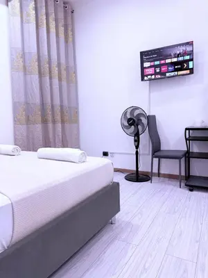 a bedroom with a bed and a fan and a chair at Gazi House in Rome