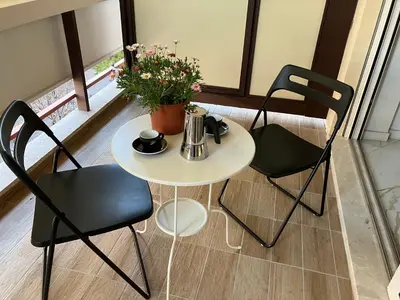 a white table with two chairs and a table with flowers at Domus4U in Rome