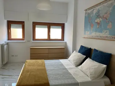 a bedroom with a bed and a desk and windows at Domus4U in Rome