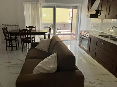 a living room with a couch and a kitchen with a table at Domus4U in Rome