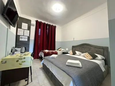 a bedroom with a bed and a desk with a television at TERMINI ROMA CENTRo in Rome