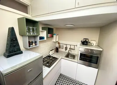 a small kitchen with white appliances and green cabinets at Residenza Merulana in Rome