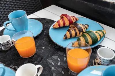 a table with two plates of sushi and two glasses of orange juice at Imperium Garbatella Guesthouse - 2 bedrooms with private bathroom, Terrace, 800mt to metro in Rome
