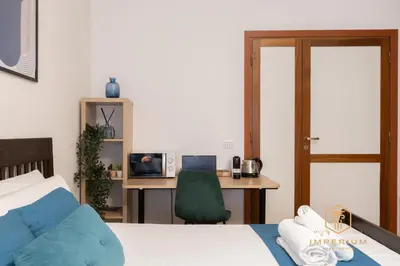 a bedroom with a bed and a desk with a computer at Imperium Garbatella Guesthouse - 2 bedrooms with private bathroom, Terrace, 800mt to metro in Rome