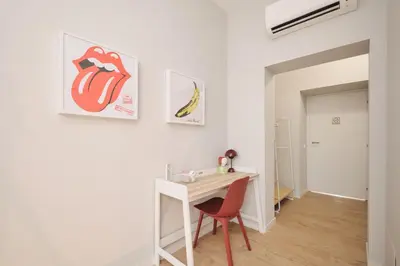 a white room with a desk and a red chair at Pop Domus Guest House o Affittacamere in Rome