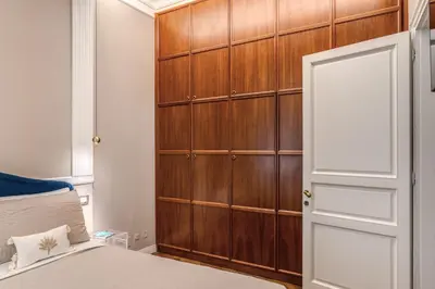 a bedroom with a wooden cabinet next to a bed at Trevi Central Suite in Rome