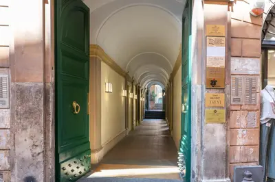 an alleyway in an old building with green doors at Trevi Central Suite in Rome