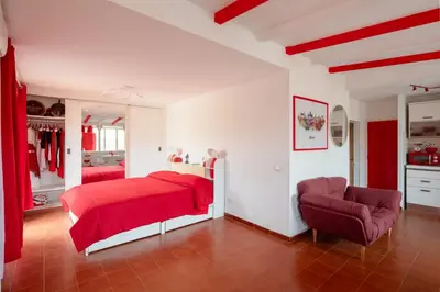 a bedroom with a red bed and a chair at Vatican PENTHOUSE in Rome