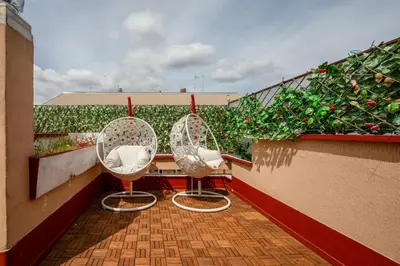 two chairs sitting on a balcony with plants at Vatican PENTHOUSE in Rome
