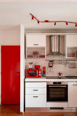 a kitchen with white cabinets and a red appliance at Vatican PENTHOUSE in Rome