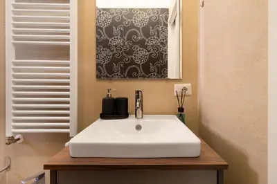 a white sink in a bathroom with a window at Candia Retreat in Rome