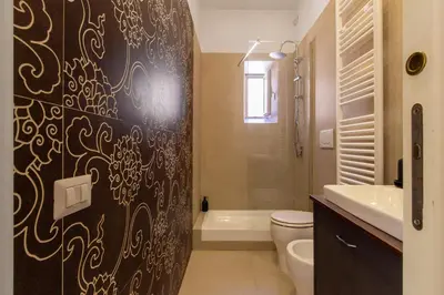 a bathroom with a black and white patterned shower curtain at Candia Retreat in Rome