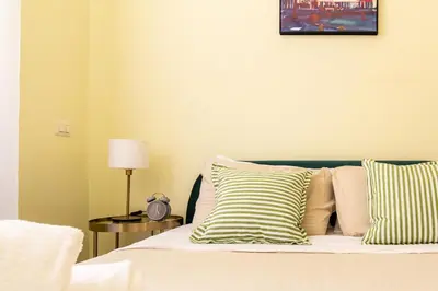 a bed with striped pillows and a picture on the wall at Candia Retreat in Rome