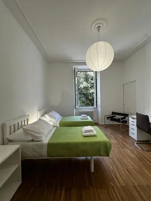 a bedroom with a bed with a green blanket at La Casabella Rome Center in Rome