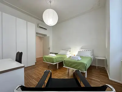 a room with two beds and a table and chairs at La Casabella Rome Center in Rome