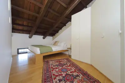 a bedroom with a bed and a rug at YCH-Splendido attico con terrazzo a San Giovanni in Rome