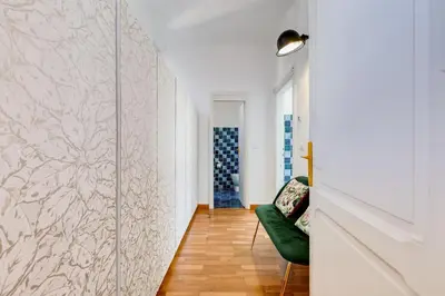 a hallway with a green chair and a wall at Attico incantevole con idromassaggio e terrazzo in Rome