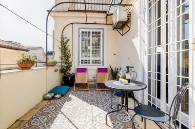 a small patio with a table and chairs on a balcony at Attico incantevole con idromassaggio e terrazzo in Rome
