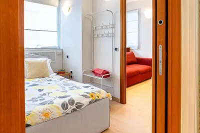 a bedroom with a bed and a red chair at Appartamento Vacanze a Roma San Giovanni - Affitto Breve, Comfort Moderno e Posizione Centrale in Rome