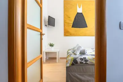 a room with a couch and a picture of a dress on the wall at Appartamento Vacanze a Roma San Giovanni - Affitto Breve, Comfort Moderno e Posizione Centrale in Rome
