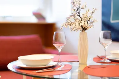 a table with two wine glasses and a vase with flowers at Appartamento Vacanze a Roma San Giovanni - Affitto Breve, Comfort Moderno e Posizione Centrale in Rome