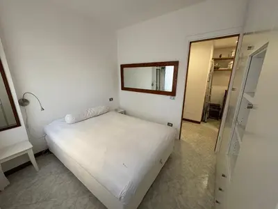 a white bedroom with a bed and a mirror at La Casa di Valentina in Rome