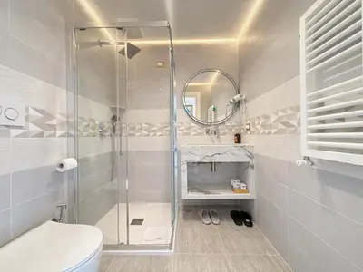 a bathroom with a shower and a toilet and a mirror at Luxe roma in Rome