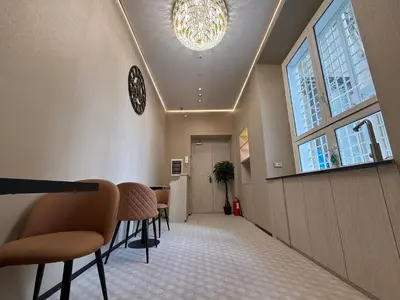 a hallway with a waiting room with chairs and a chandelier at Luxe roma in Rome