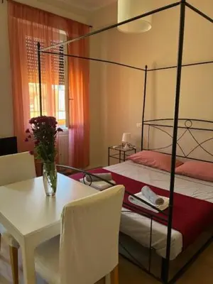 a bedroom with a bed and a table with a vase of flowers at Mila house suite in Rome