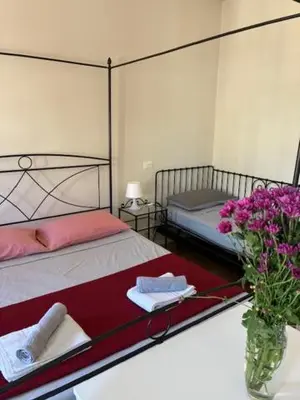 a bedroom with a bed and a table with flowers at Mila house suite in Rome