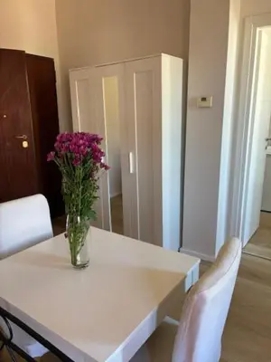 a vase of flowers sitting on a table with two chairs at Mila house suite in Rome