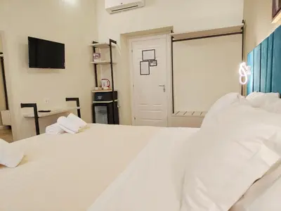 a bedroom with two white beds and a television at Nicole Suite in Rome