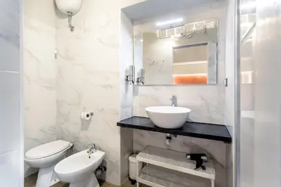 a white bathroom with a sink and a toilet at Nicole Suite in Rome