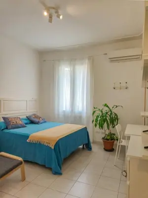 a bedroom with a blue bed and a window at Quiet, Cozy flat near citycenter in Rome