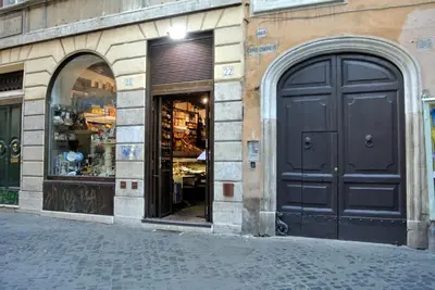 a store front with a black door on a street at Campo De’ Fiori Prestige Rooms in Rome