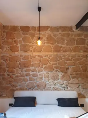 a stone wall with a couch and a light fixture at Hortus in Rome