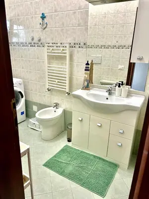 a bathroom with a sink and a toilet and a mirror at La casa di Roby in Rome