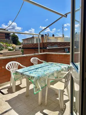 a table and chairs on a patio with a view of a building at La casa di Roby in Rome