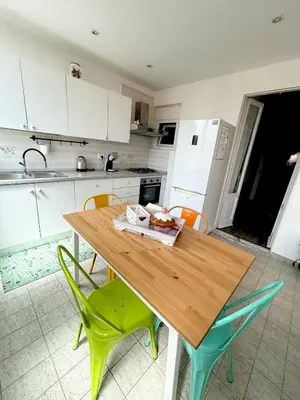 a kitchen with a wooden table and green chairs at La casa di Roby in Rome