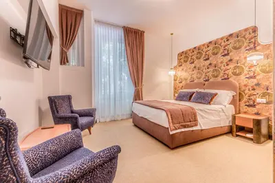 a hotel room with a bed and a chair at Sophia B&B 94 Trastevere in Rome
