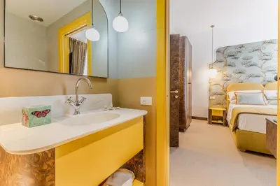 a bathroom with a sink and a bedroom at Sophia B&B 94 Trastevere in Rome