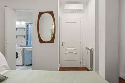 a bedroom with a white door and a mirror at Betti Classic Home in Rome