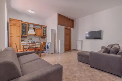 a living room with two couches and a kitchen at Furi Loft Garden in Rome