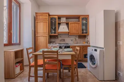 a kitchen with a table and chairs and a washing machine at Furi Loft Garden in Rome