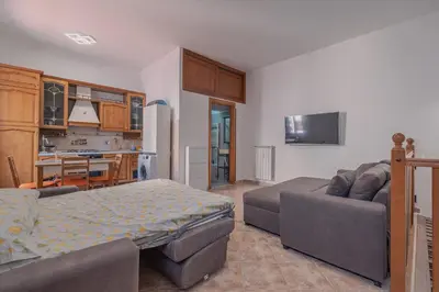 a living room with a couch and a kitchen at Furi Loft Garden in Rome