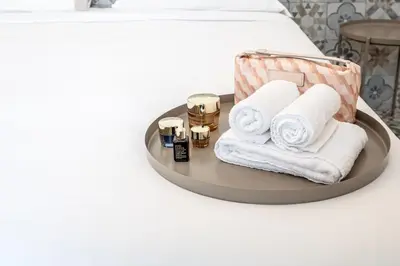 a tray with towels and cosmetics on a bed at Aeterna RHome - Domus Piramide in Rome