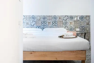 a bedroom with two beds with white sheets and a headboard at Aeterna RHome - Domus Piramide in Rome